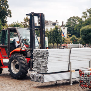 Forklift delivers metal profile from warehouse for construction of building.